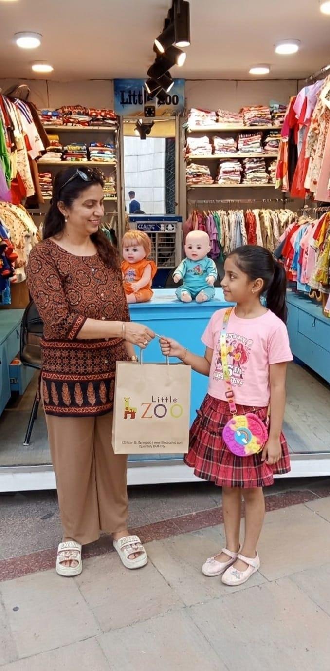 Customer receiving a Little Zoo shopping bag at the store counter